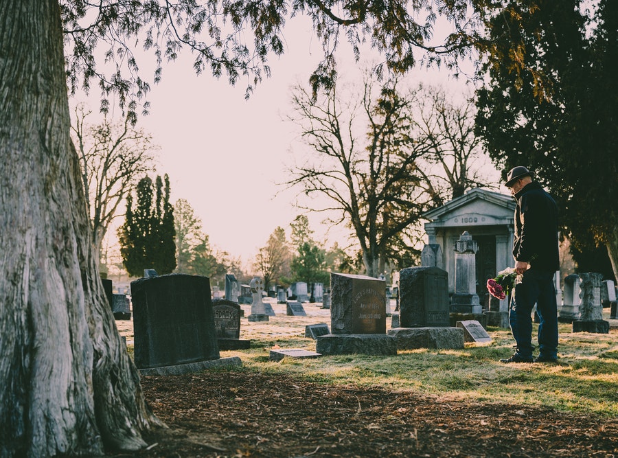 un homme se recueille devant une tombe au cimetière - pompes funèbres à lyon